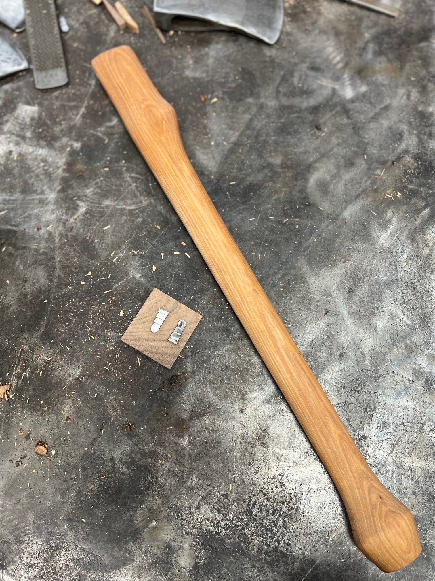 A hickory wood axe handle with textured grip securely fastened to a metal axe head for efficient logging tasks